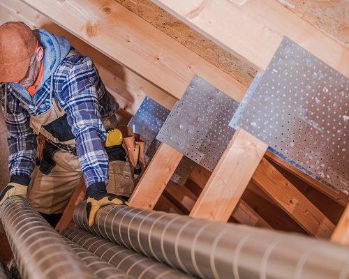 worker fixing the air duct repair